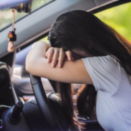 Woman slumped over steering wheel