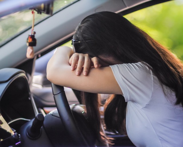 Woman slumped over steering wheel