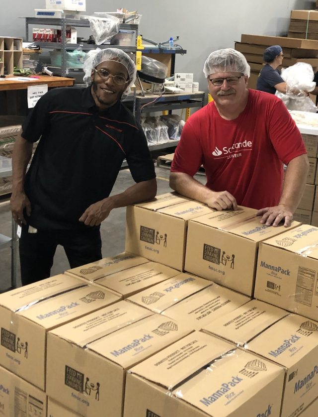 “Starving Children” volunteers with packed food boxes