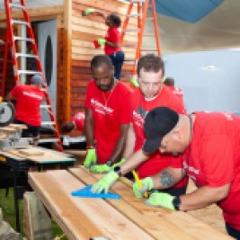 Volunteers measure siding for tiny houses for veterans