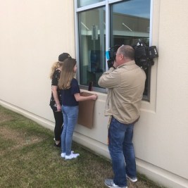 Girl holds up sign for grandfather at hospital
