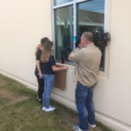 Girl holds up sign for grandfather at hospital