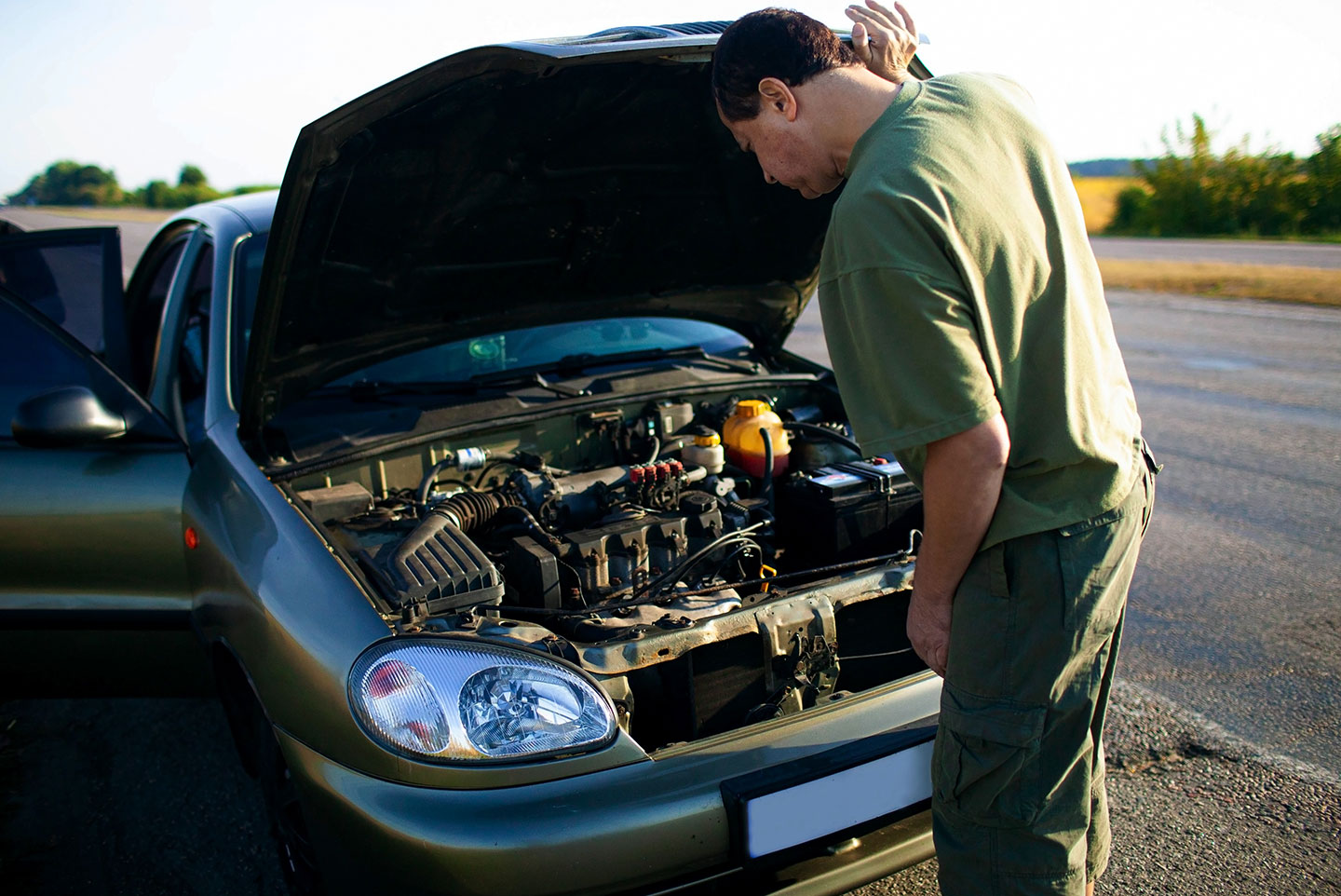 Man looking at car engine